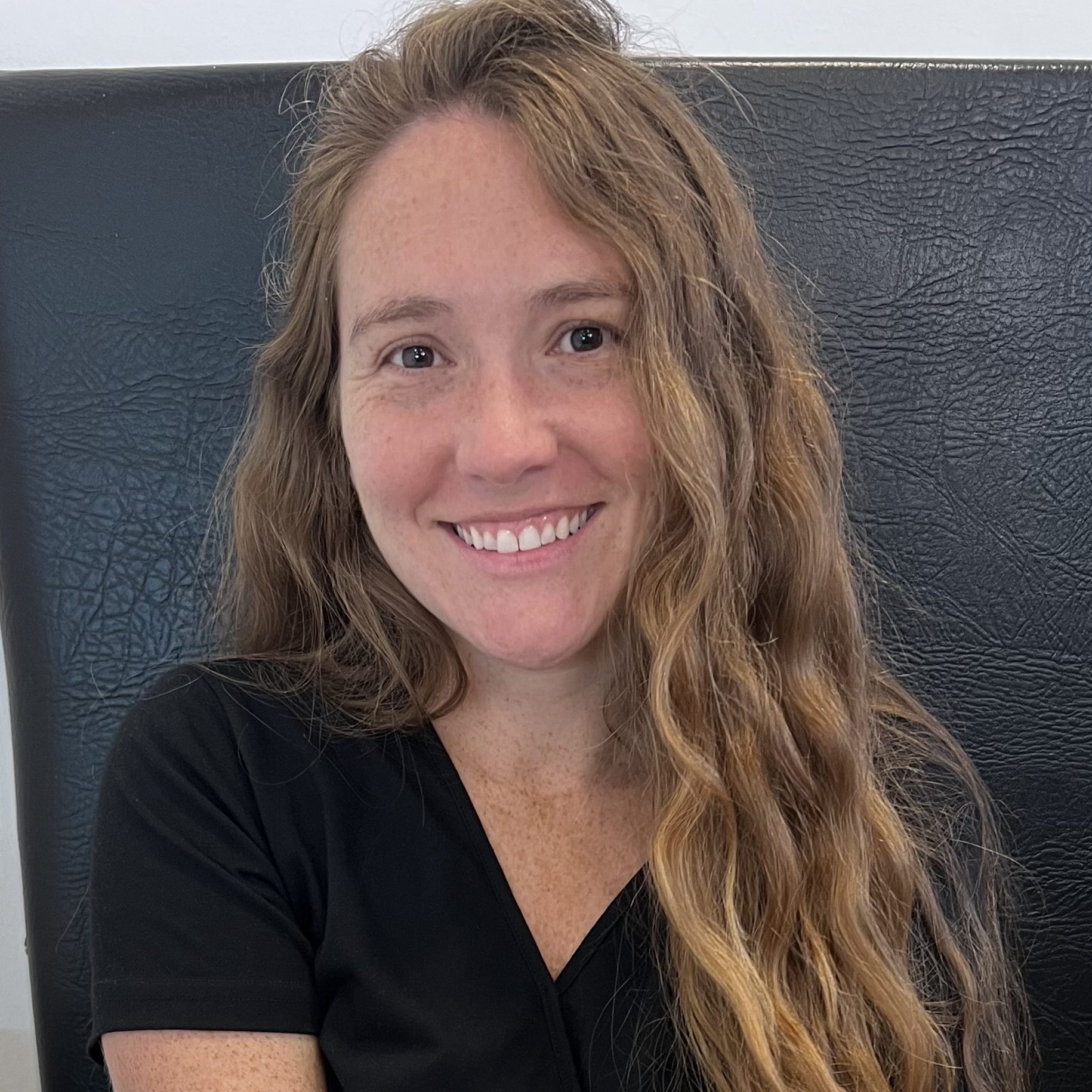 Image of Melanie Calhoun, a counsellor and psychotherapist with long, wavy strawberry blonde hair and a black top.