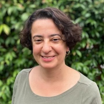 Image of Sandra Angus, an integrative counsellor with short brown hair and a khaki shirt, supporting young adults with issues surrounding identity and life transitions.