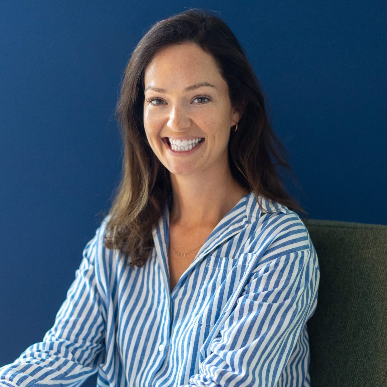 Emily Reynolds, an integrative counsellor and psychotherapist, smiling warmly at the camera in a professional portrait.