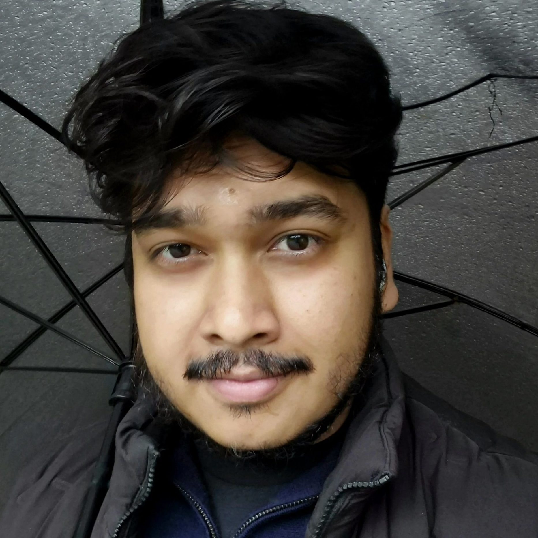 Portrait of Farhan Firoz, a counsellor and psychotherapist, smiling at the camera in a professional photo.