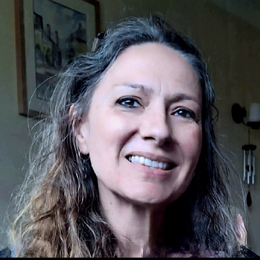 Joanna Whelan, psychodynamic psychotherapist supporting individuals and couples in Guildford with brown wavy hair and a windchime in the background.